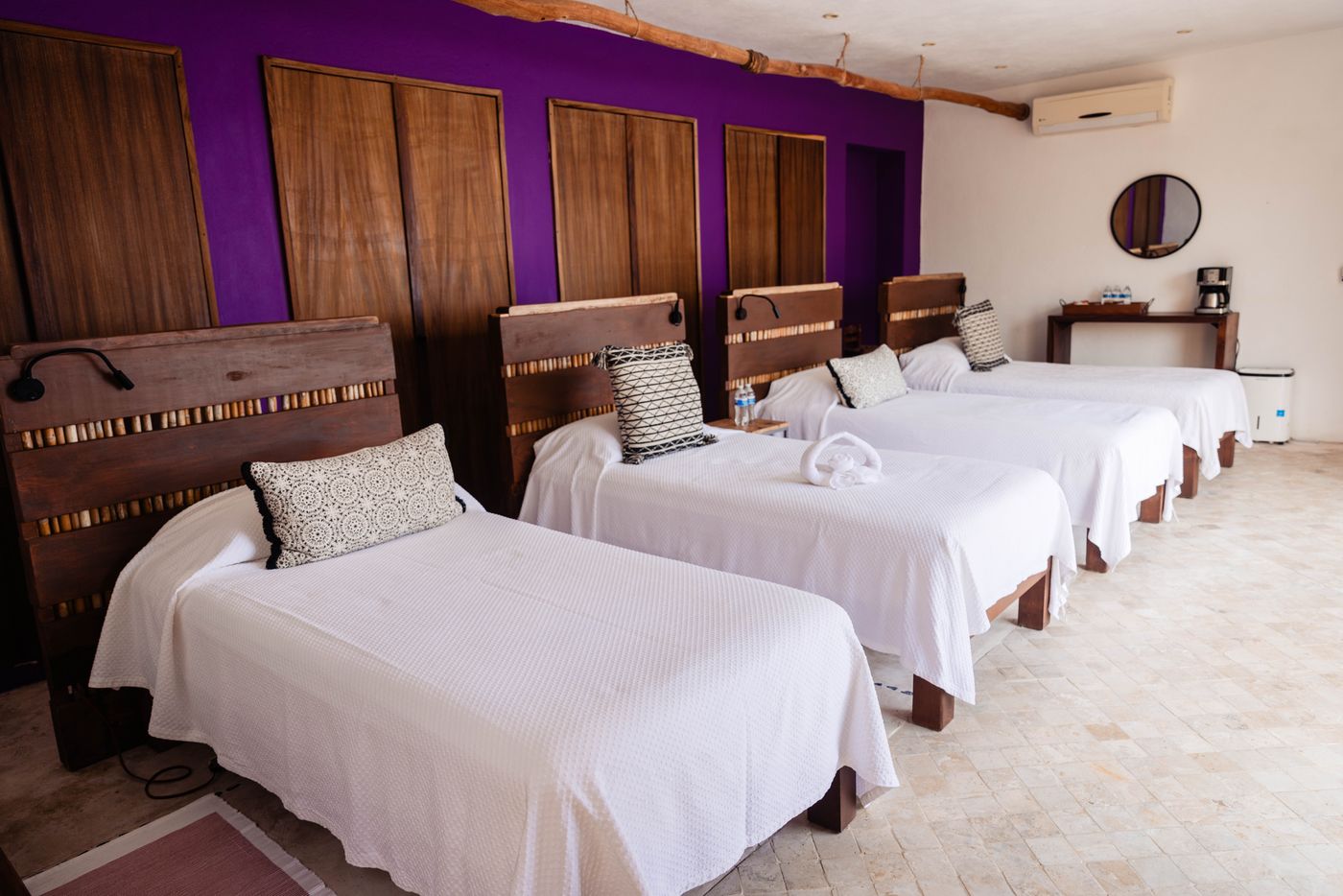 Bedroom with four single beds and a purple accent wall at Villa Mandarinas