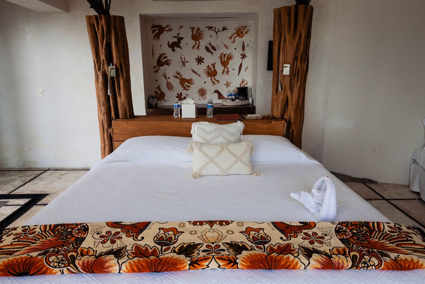 Bedroom with a bed, patterned throw and carved wood posts at Villa Mandarinas