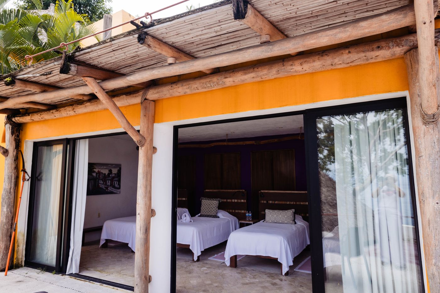Pergola-covered terrace looking into a bedroom with twin beds at Villa Mandarinas